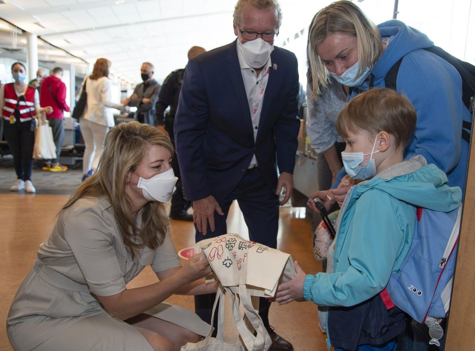 M\u00e9lanie Joly and Jean Boulet chat with a Ukrainian child.