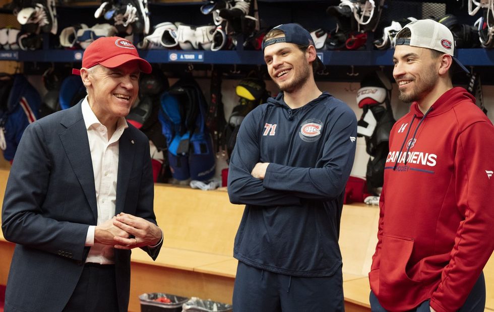 Mark Carney, Jake Evans and Nick Suzuki laugh together in the Habs dressing room.