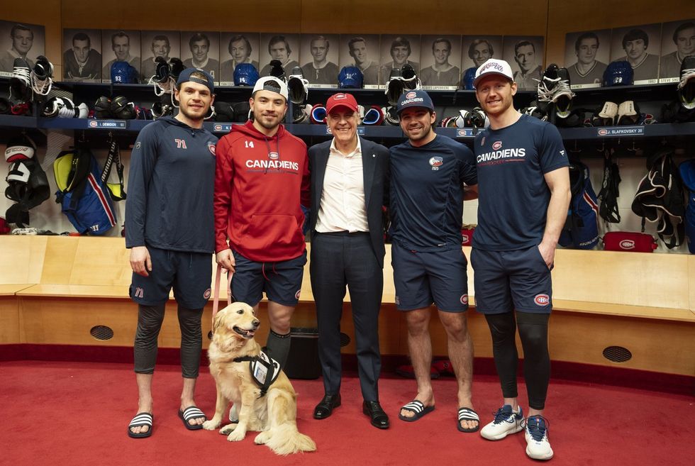 Mark Carney poses with Habs player in the dressing room.