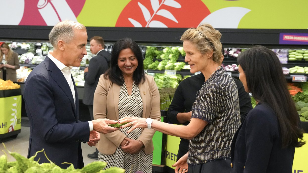 Mark Carney shows his wife an Indian bitter melon at a FreshCo grocery store.
