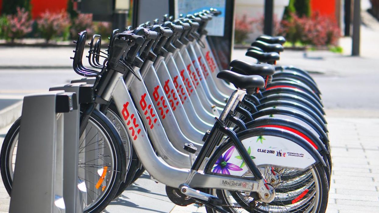 Montreal BIXI bikes parked in a station on a sidewalk.