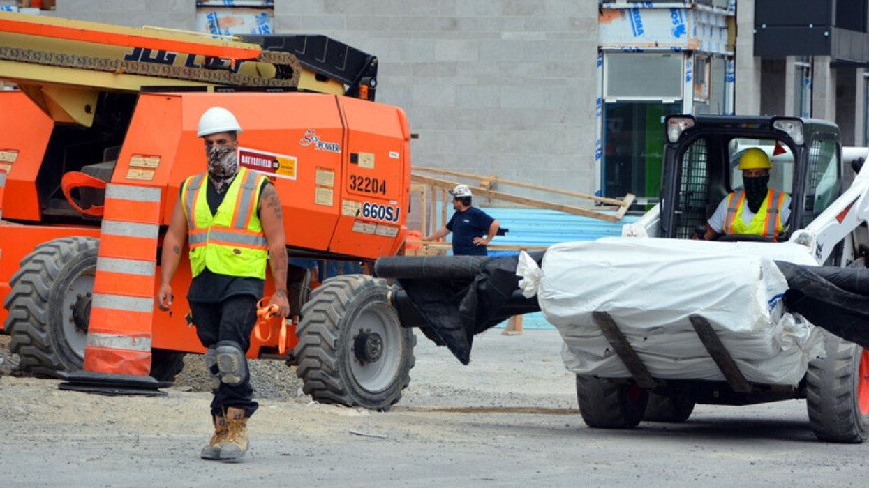 Montreal construction workers work on a job site.