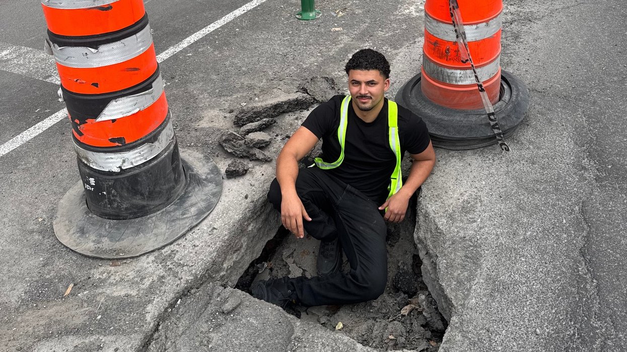 Montreal landscaper Saâd Tekiout sitting inside a pothole.