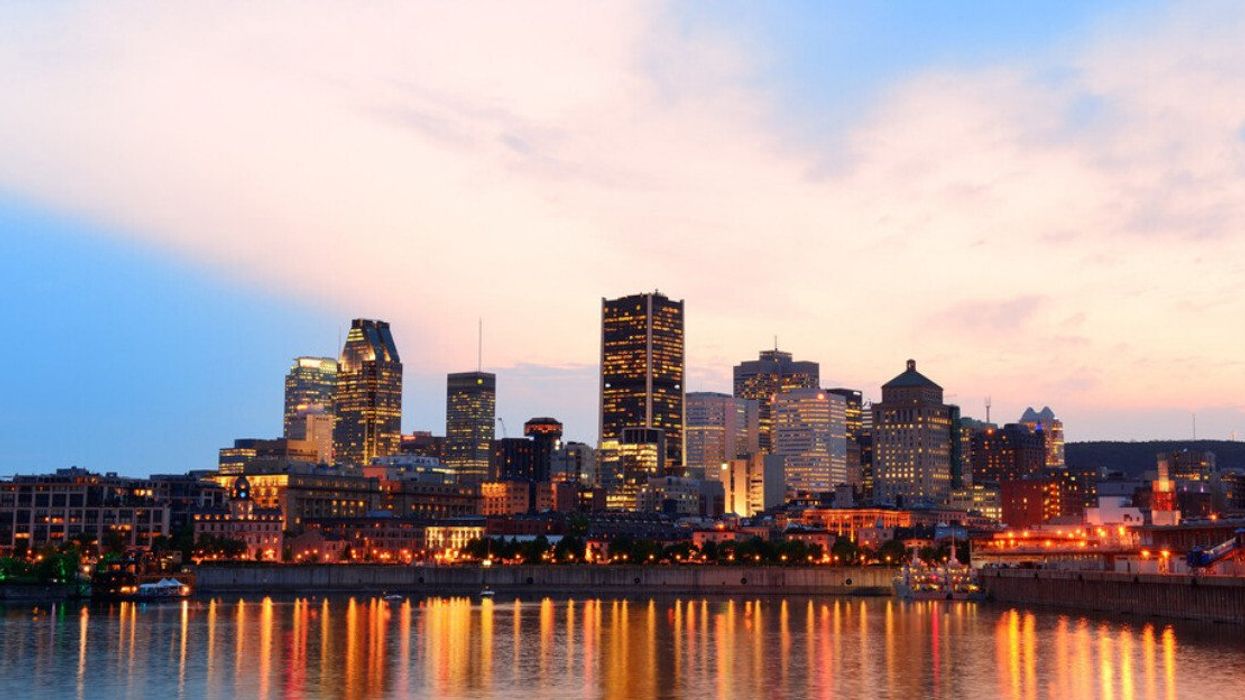 Montreal over river at sunset with city lights and urban buildings.