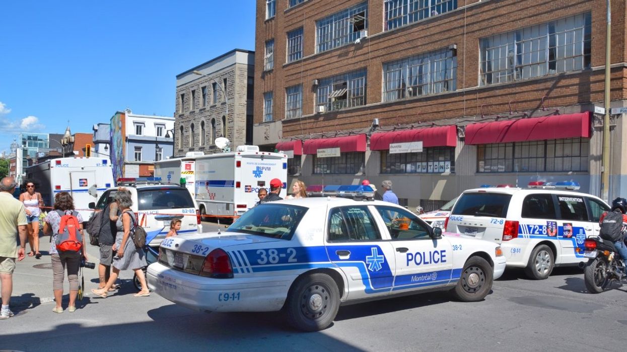 Montreal police cars and trucks parked on a Montreal street during the summer.