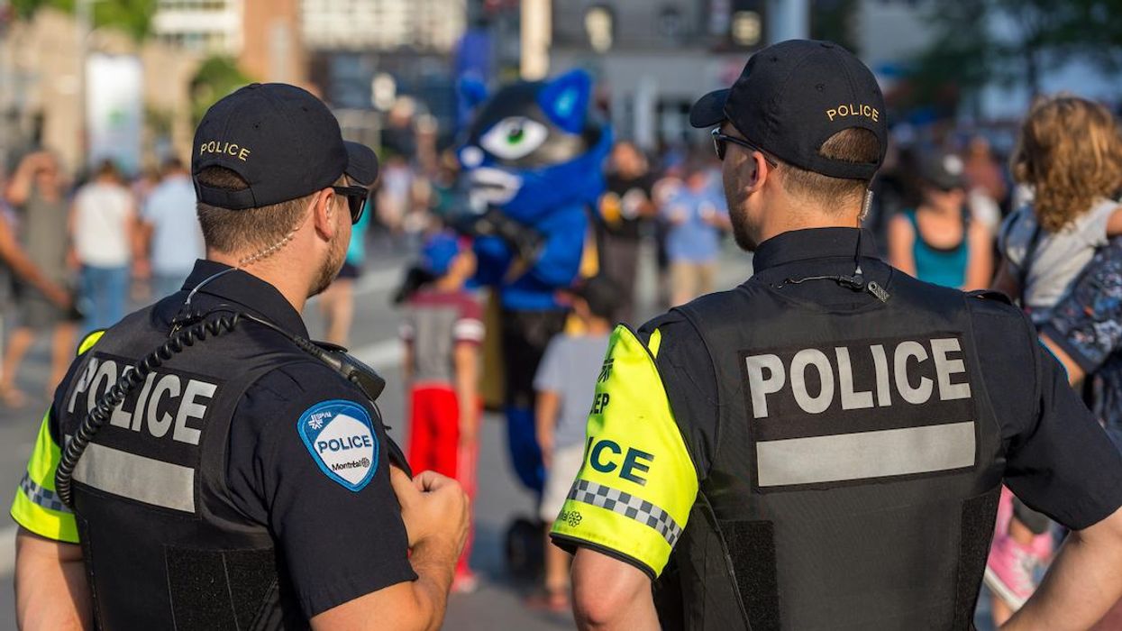 Montreal police officers observe a crowd.