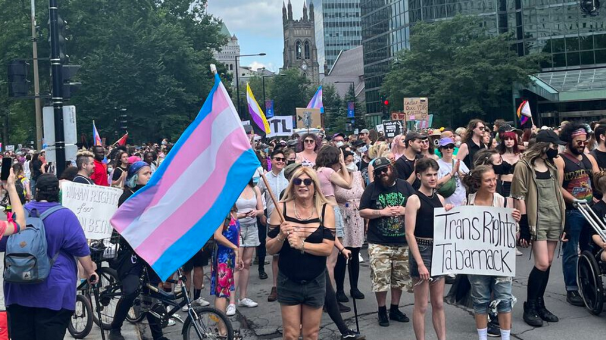 Montreal's 2023 Trans March begins from the Place du Canada, with flags and signs flying high.