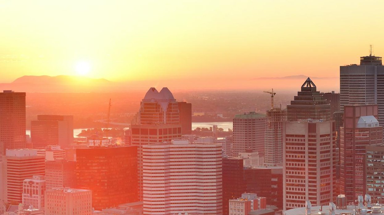 Montreal skyline seen from Mount Royal with the sun rising on the horizon.