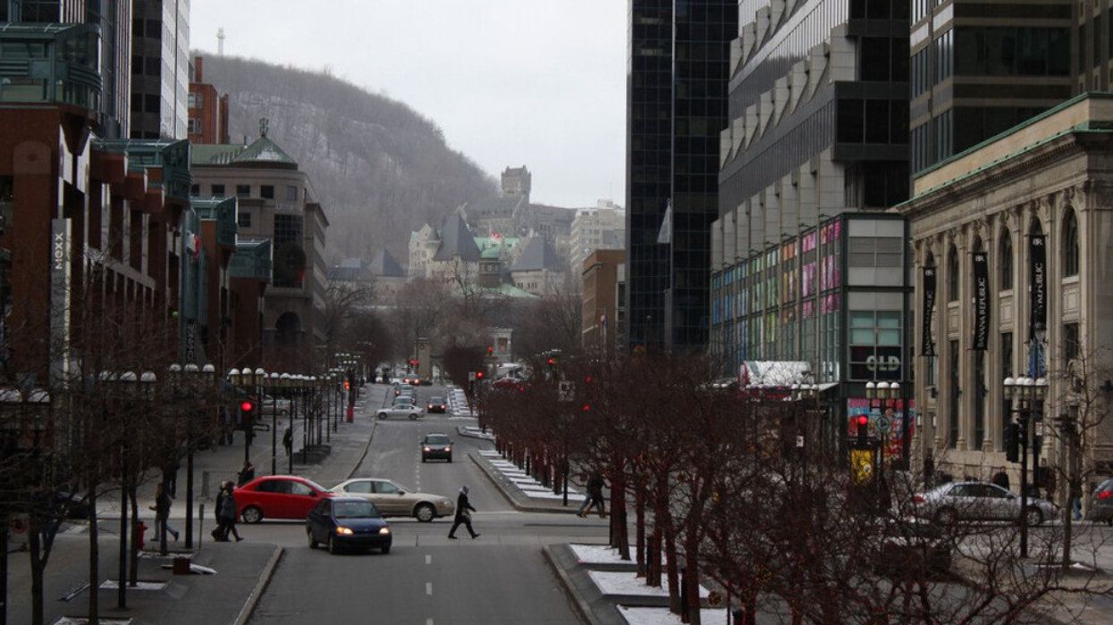 Office towers, retail shops, and restaurants line McGill College Avenue in downtown Montreal on a winter day.