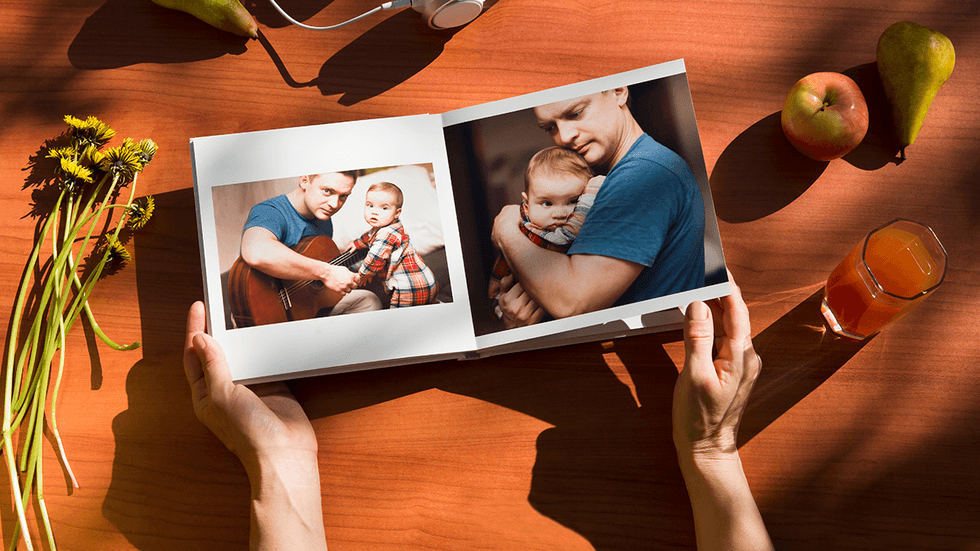 Open photobook with family photos on a wooden table.