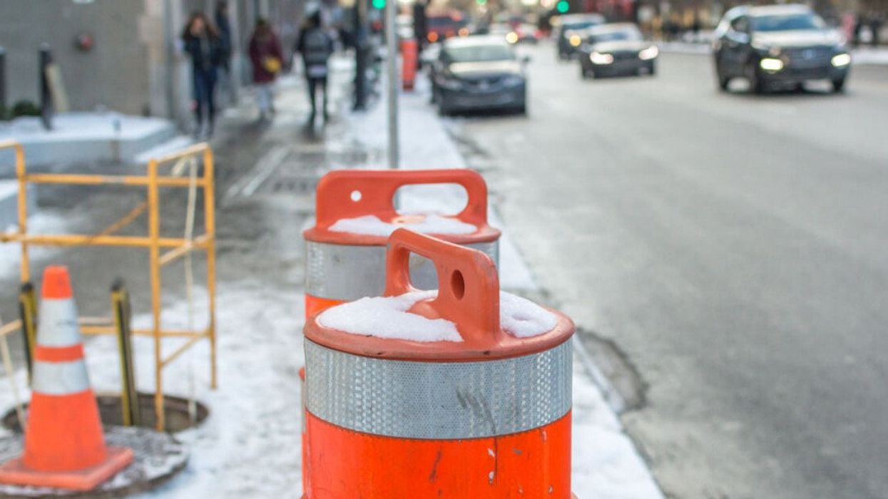 Orange traffic cones on a sidewalk in downtown Montreal.