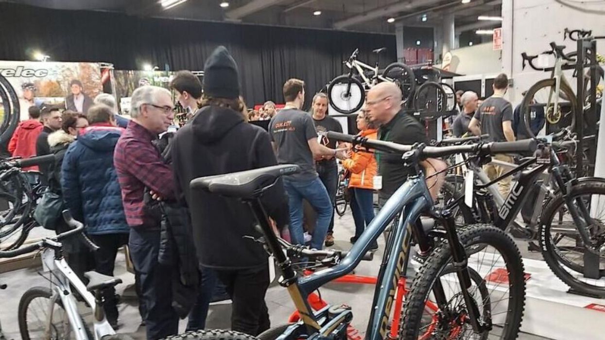 People in a showroom filled with bikes.