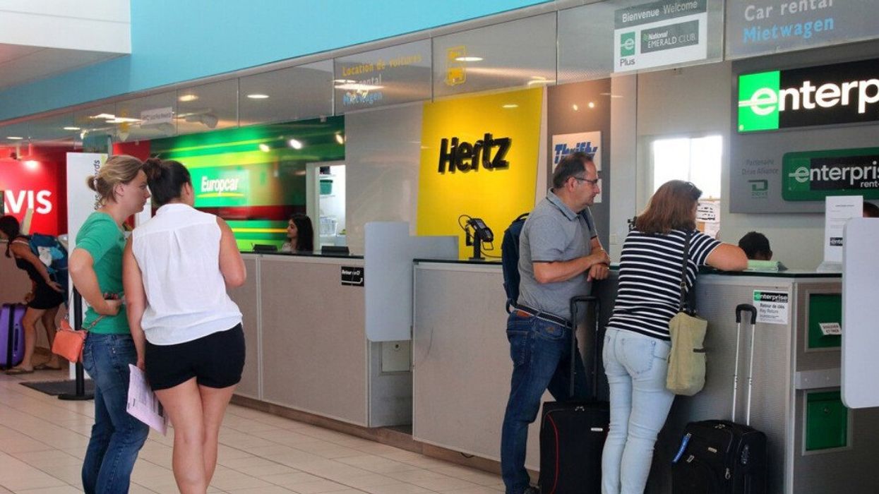 People in line at a car rental counter.