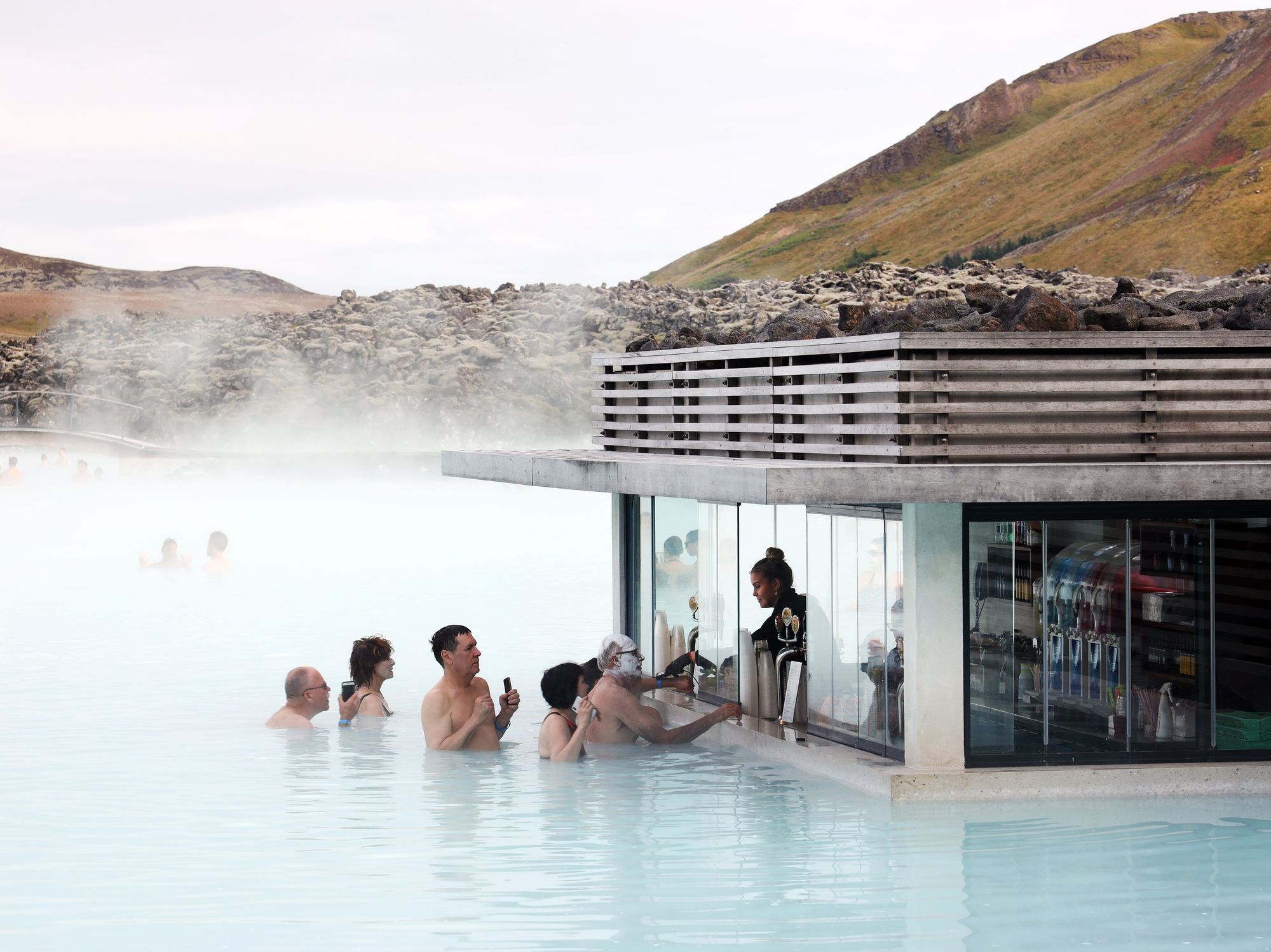 People line up for a waterside vendor at the Blue Lagoon geothermal spa in southwestern Iceland, located in a lava field on the Reykjanes Peninsula..