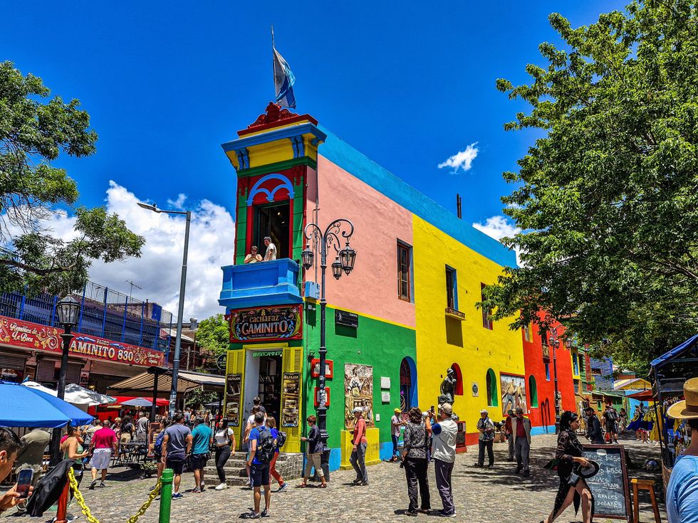 People photograph a colourful building on Caminito Street in the La Boca neighbourhood of Buenos Aires, Argentina.
