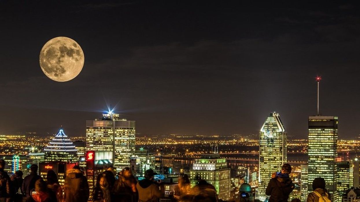 People photographing the Montreal nighttime skyline with supermoon.