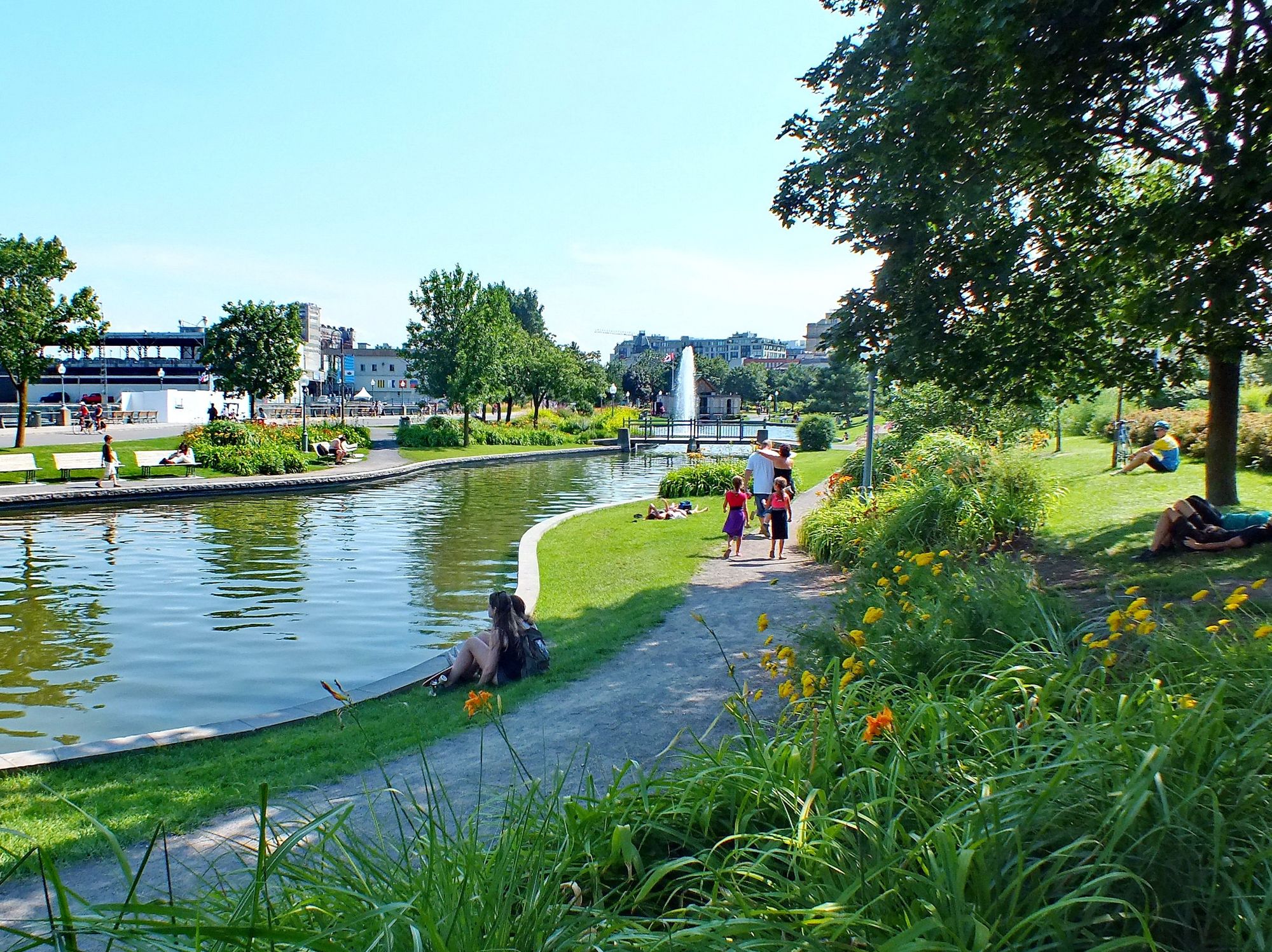 People sit by a water fountain in Montreal's Old Port.