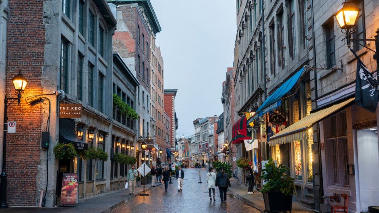 People stroll through Old Montreal in the rain.