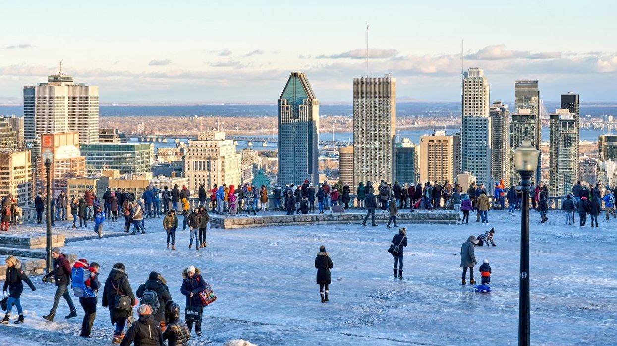 People visiting the Mont‐Royal chalet overlooking the Montreal skyline during the wintertime.