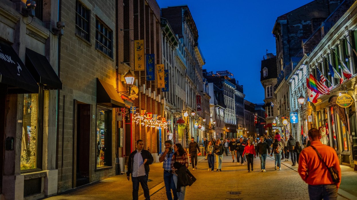 People walk around Old Montreal at night.