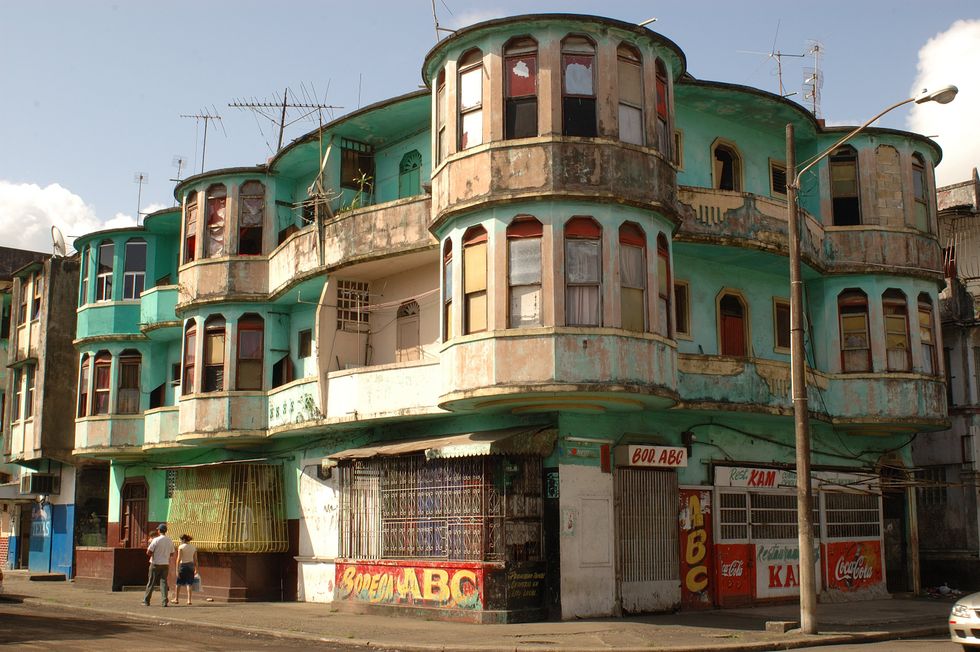 People walk by apartments in Col\u00f3n, Panama.