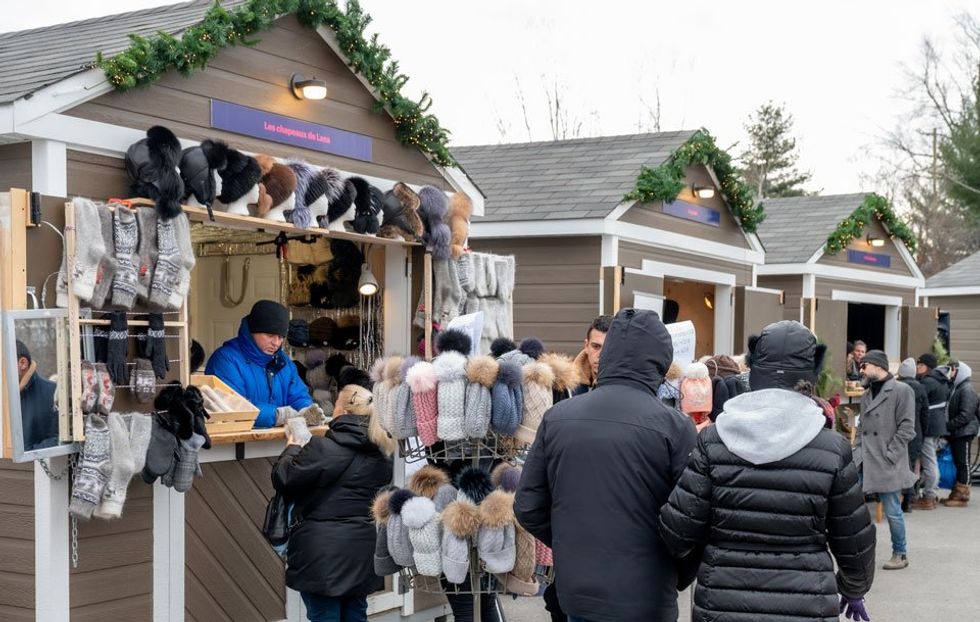 People walk by artisanal booths at the Laval Christmas Market.