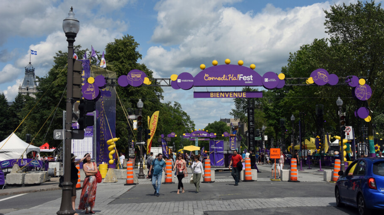 People walk in an outdoor square set-up for ComediHa! Fest in Quebec City, Canada in 2019.