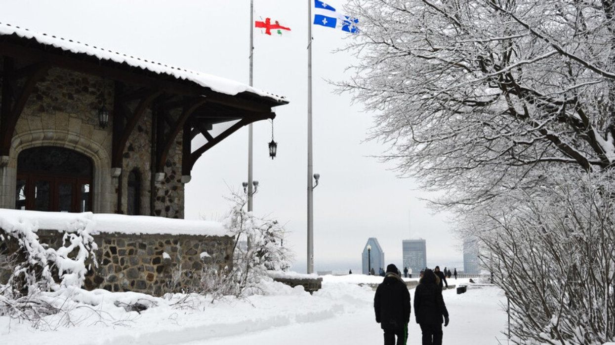 People walk in snow toward the Mount Royal outlook.
