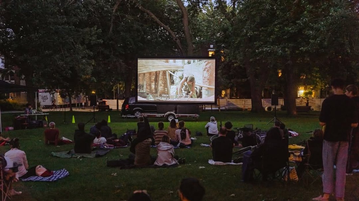 People watch a movie in a Montreal park.