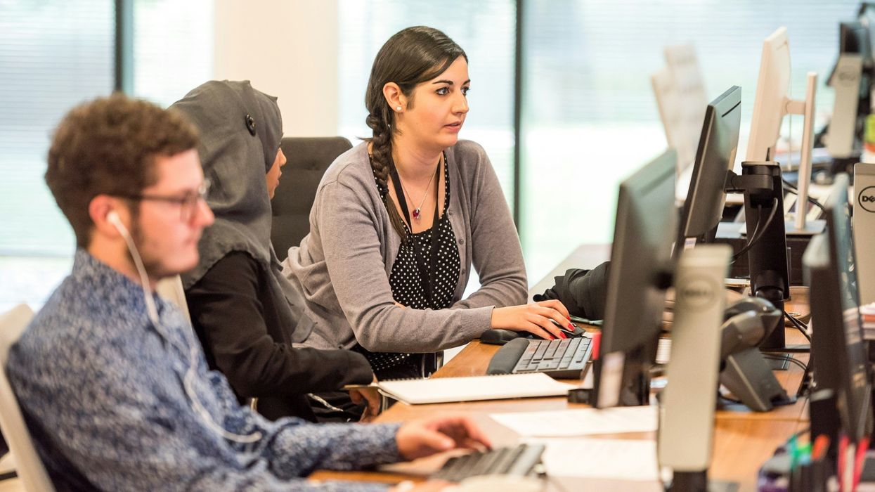 people working on computers at desks in an office