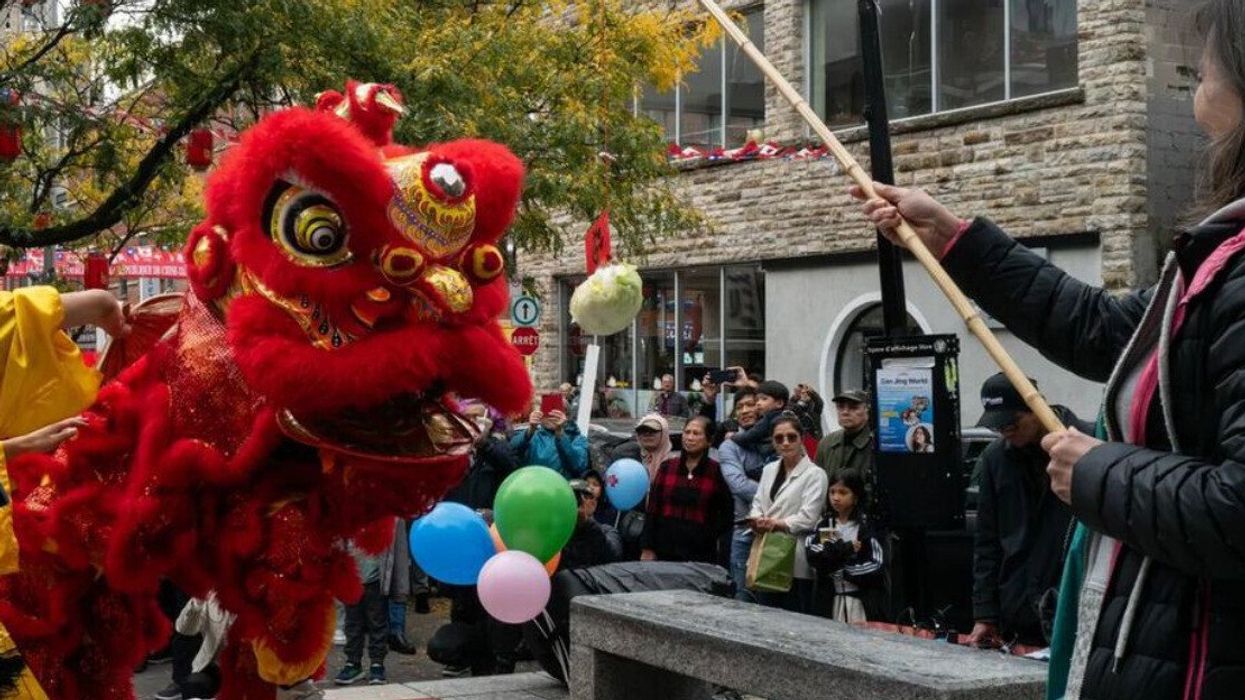 Performers in a traditional lion costume dance in Montreal's Chinatown.