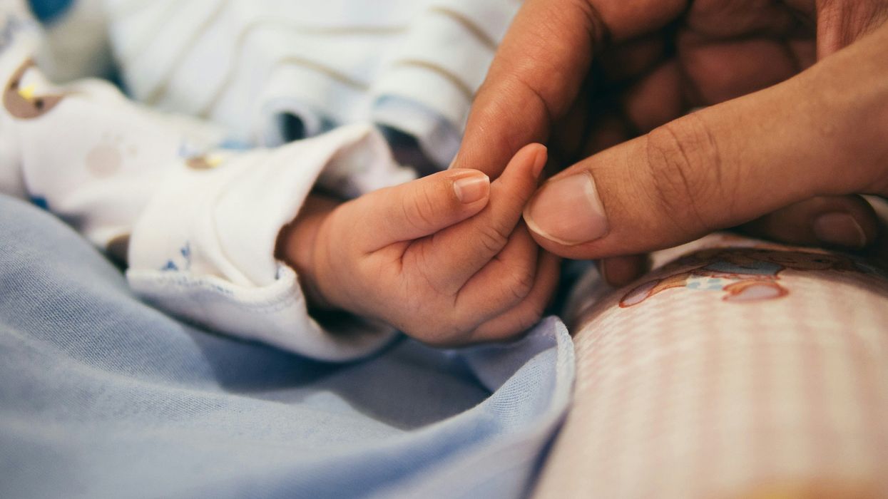 person holding baby's hand