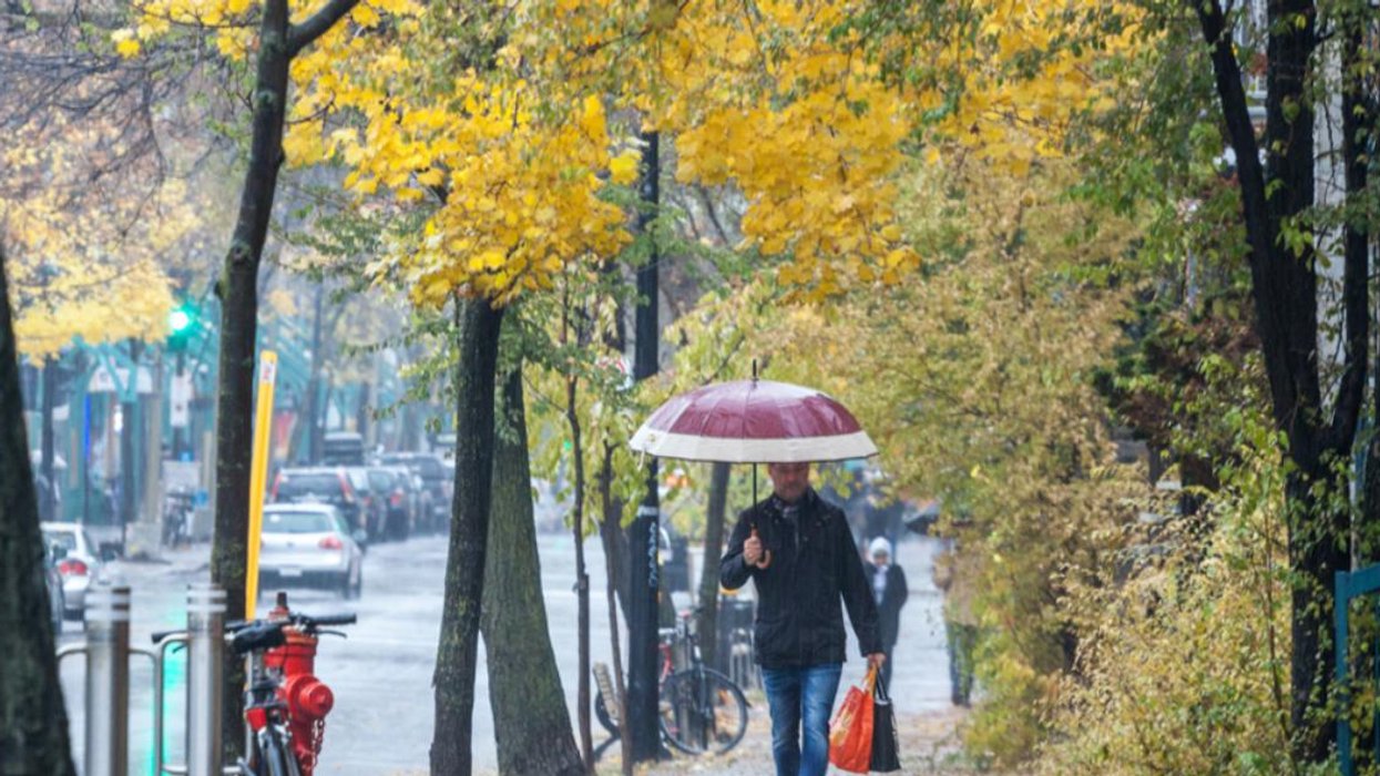 Person walking with an umbrella in the Montreal rain.