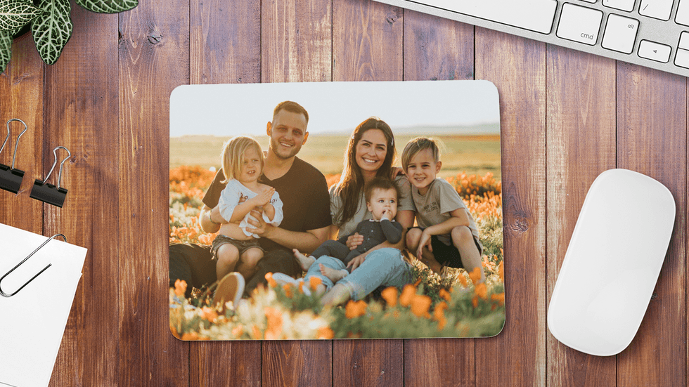Personalized mouse pad with family portrait on a desk.