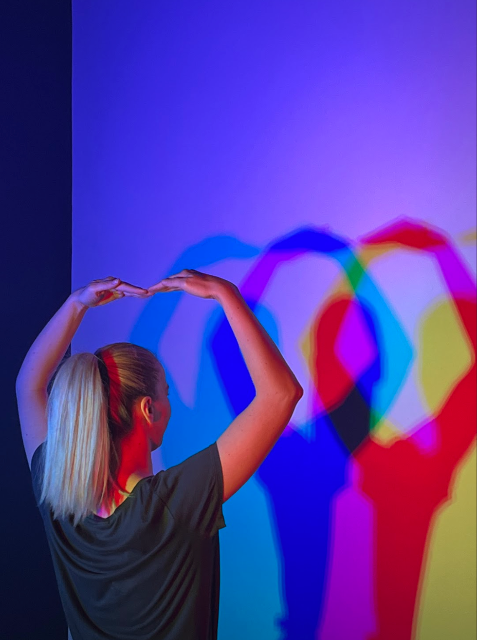 Pinju\u0161i\u0107 poses in the colour room, refracting coloured lights into their base shades.