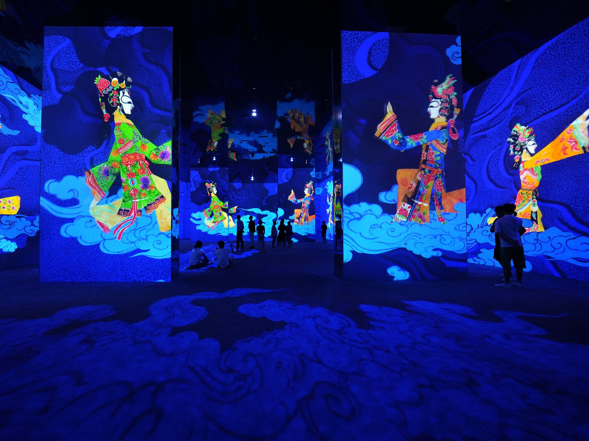 Piying shadow puppets (and viewers) walk on projected clouds.