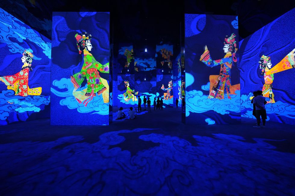 Piying shadow puppets (and viewers) walk on projected clouds.