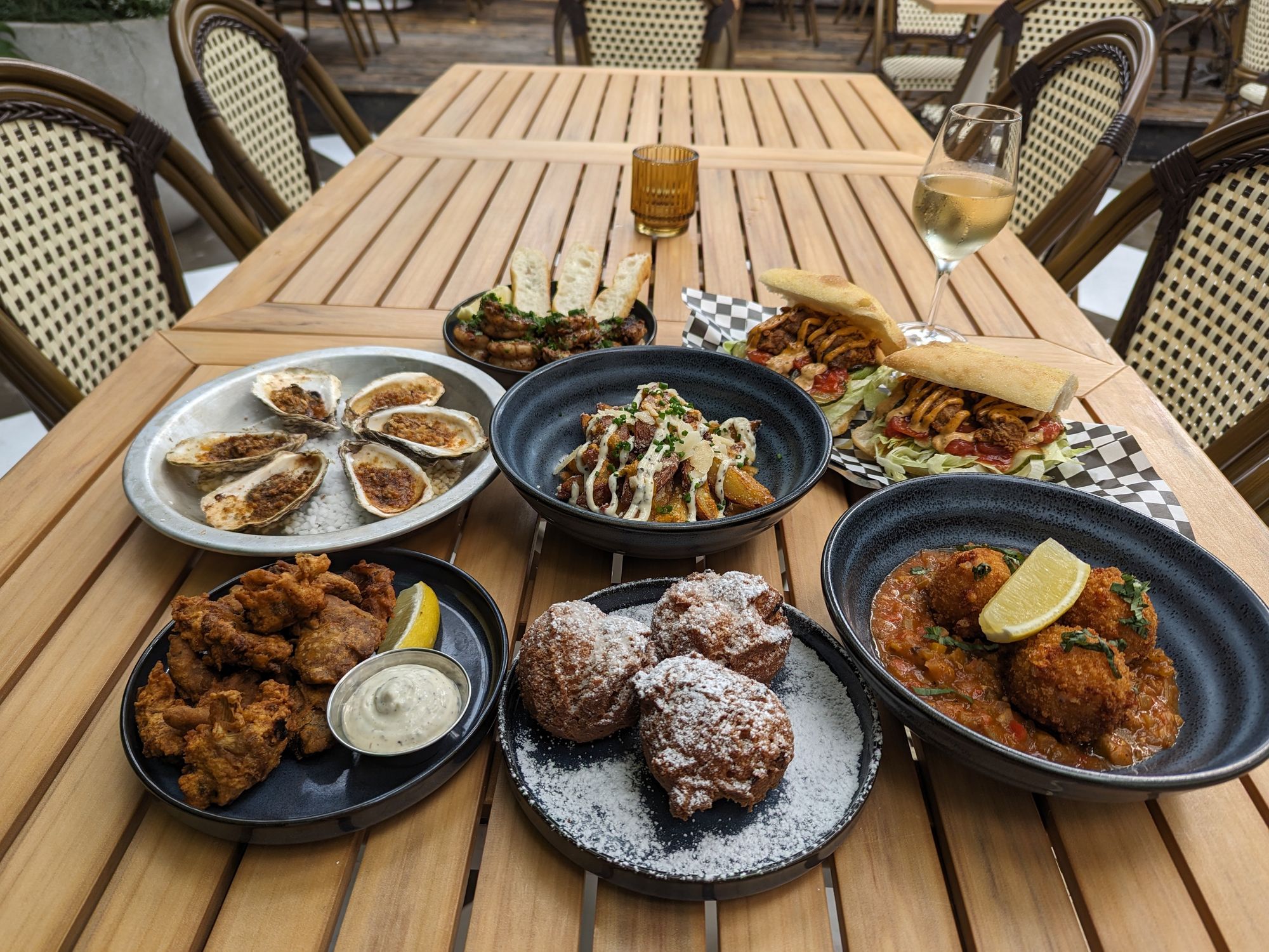 Plates of food, including oysters and beignets, at Moqueur.