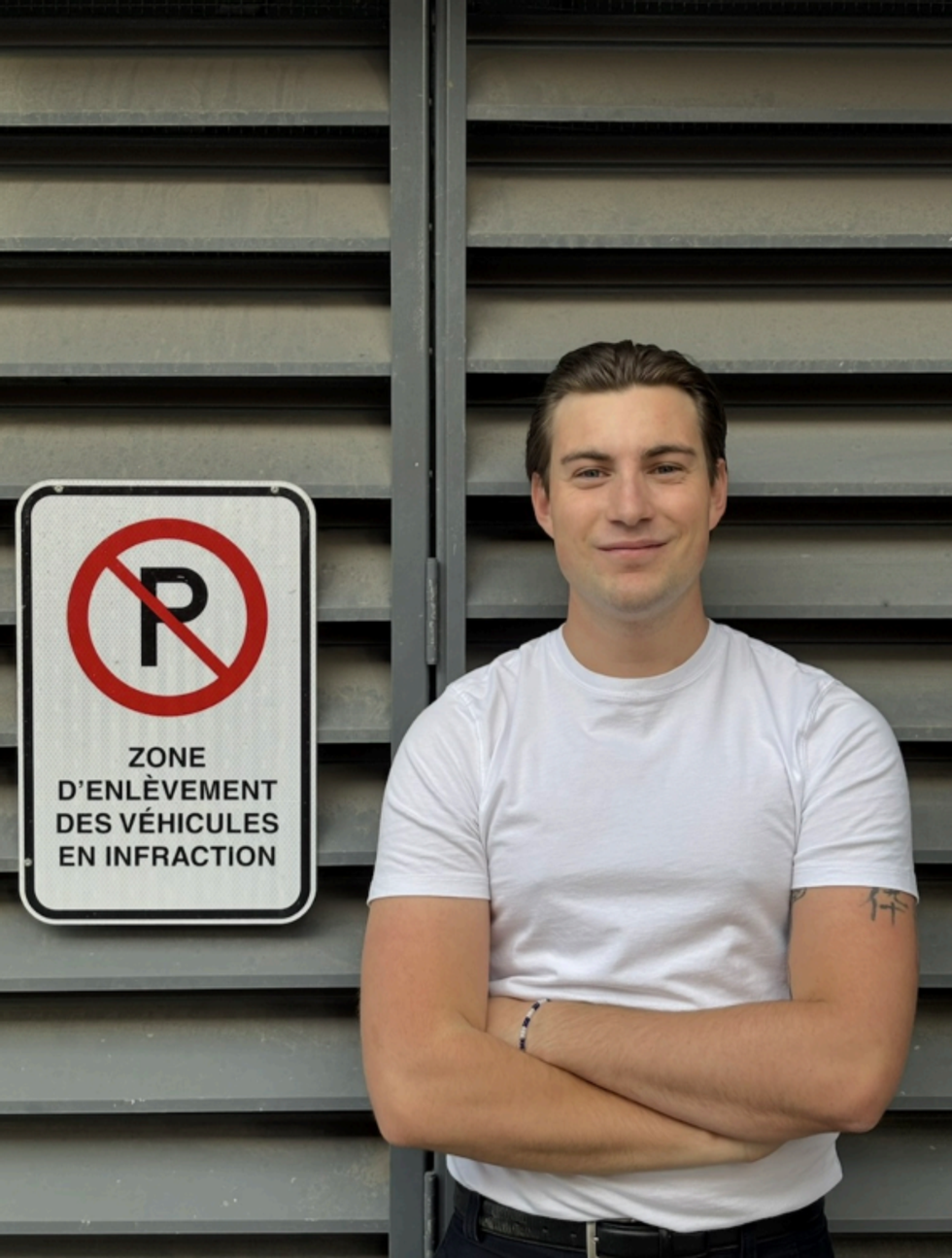 PullinParking Stationnement founder Benjamin Grenier in front of Montreal parking sign.