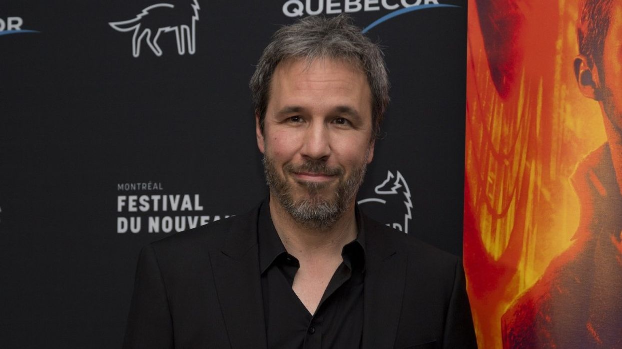 Quebec direct Denis Villeneuve posing for photos on a red carpet.