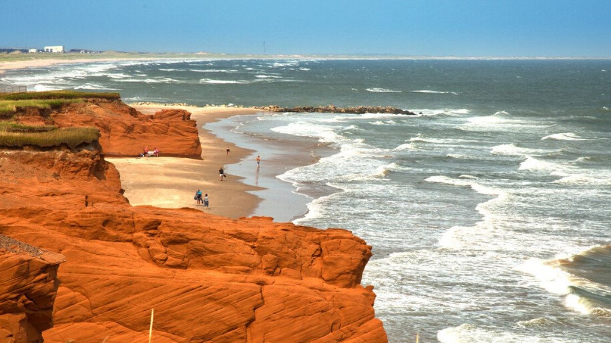 Red cliff in Havre Aubert, Quebec with waves in the ocean in the St-Lawrence river.