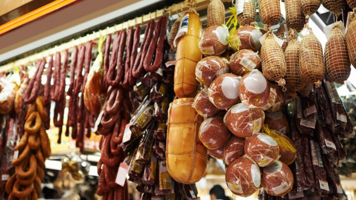 Salami hangs at a deli counter.
