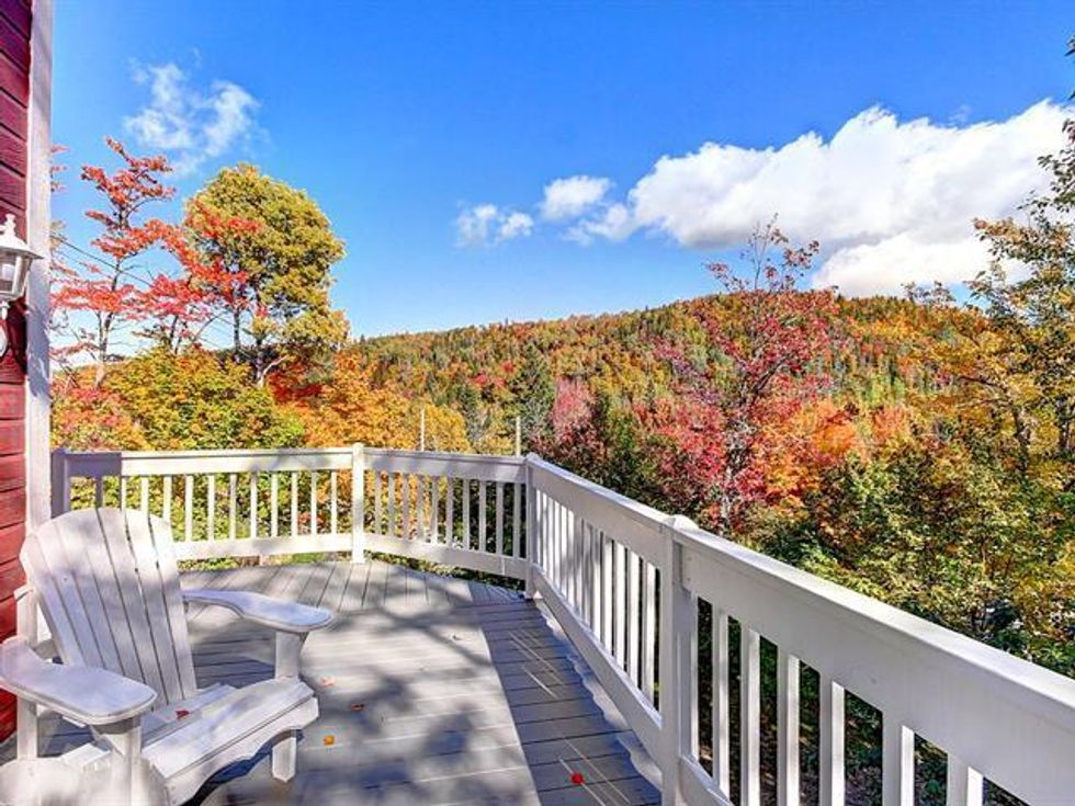 Second-storey deck on a two-unit chalet for sale in Quebec's Charlevoix region.