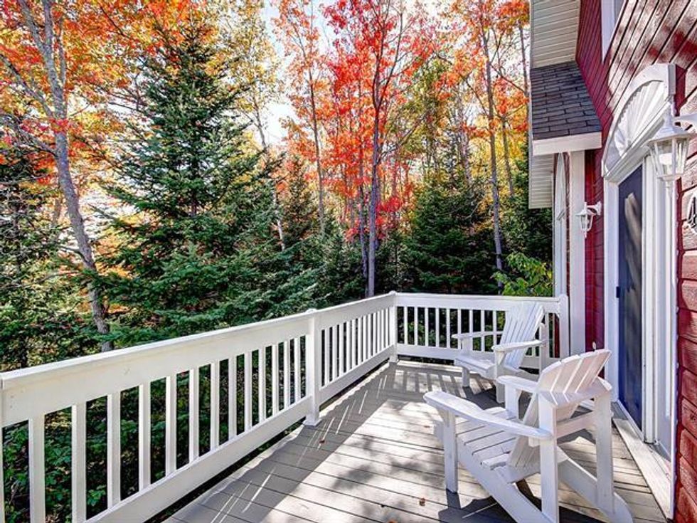 Second-storey deck on a two-unit chalet for sale in Quebec's Charlevoix region.