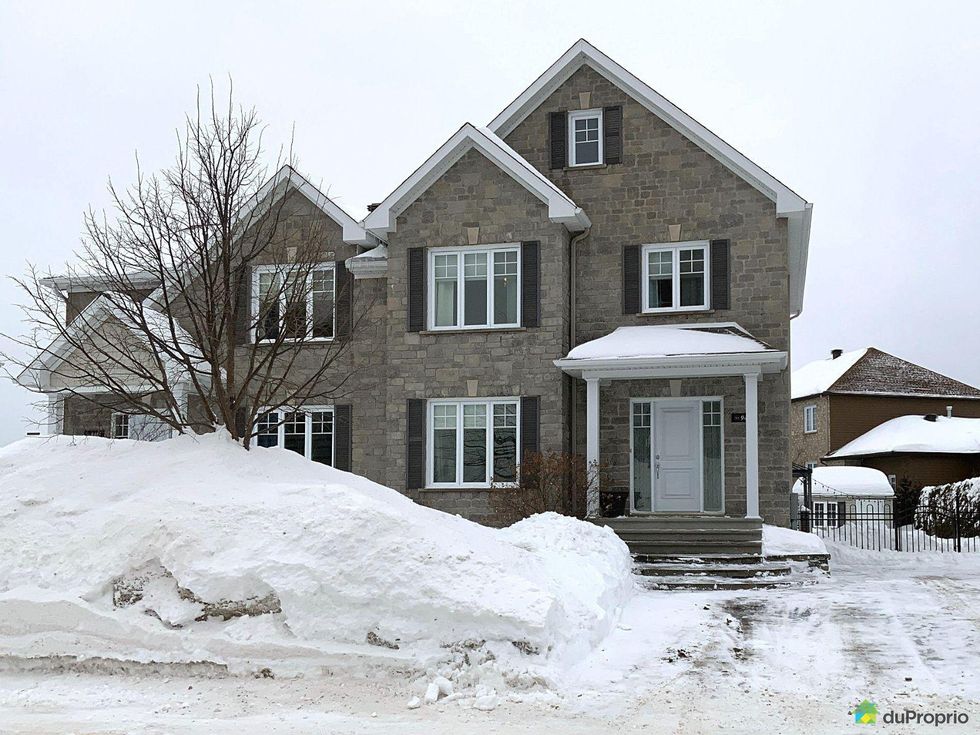 Semi-detached home for sale in Quebec City with a large pile of snow in front.