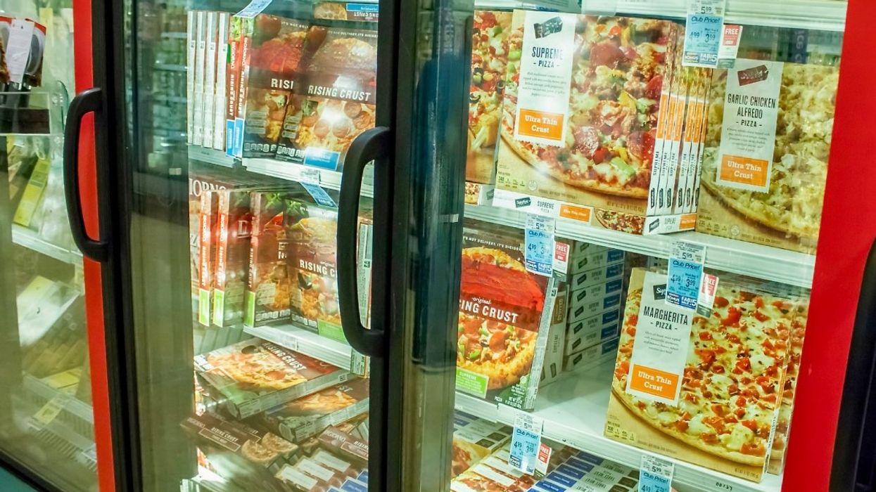 Several frozen pizza brands in the frozen section at a Canadian grocery store.