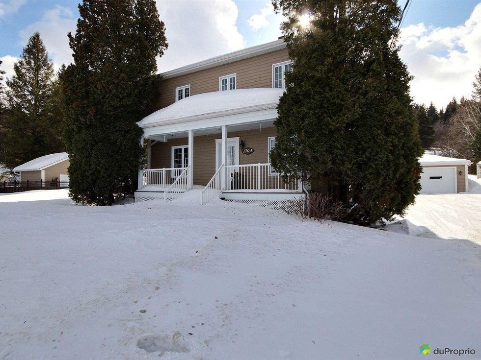 Single-family home with a large yard covered in snow in Saguenay, Quebec.