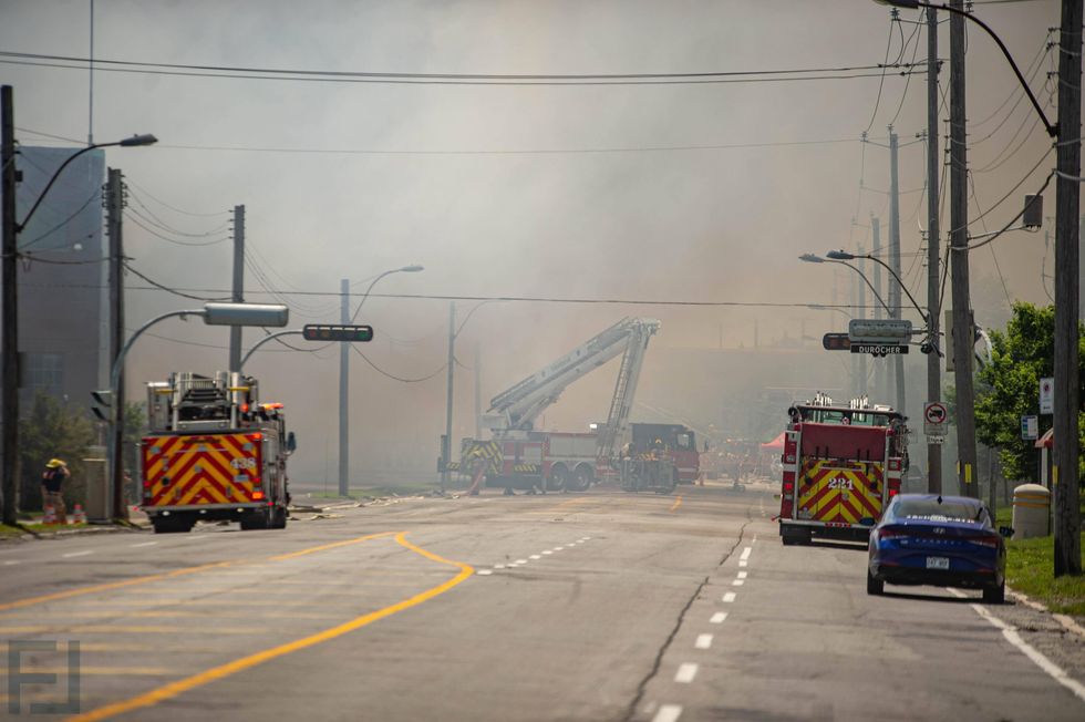 Smoke surrounds the area of a five-alarm fire in Montr\u00e9al-Est as firefighters respond on June 26.
