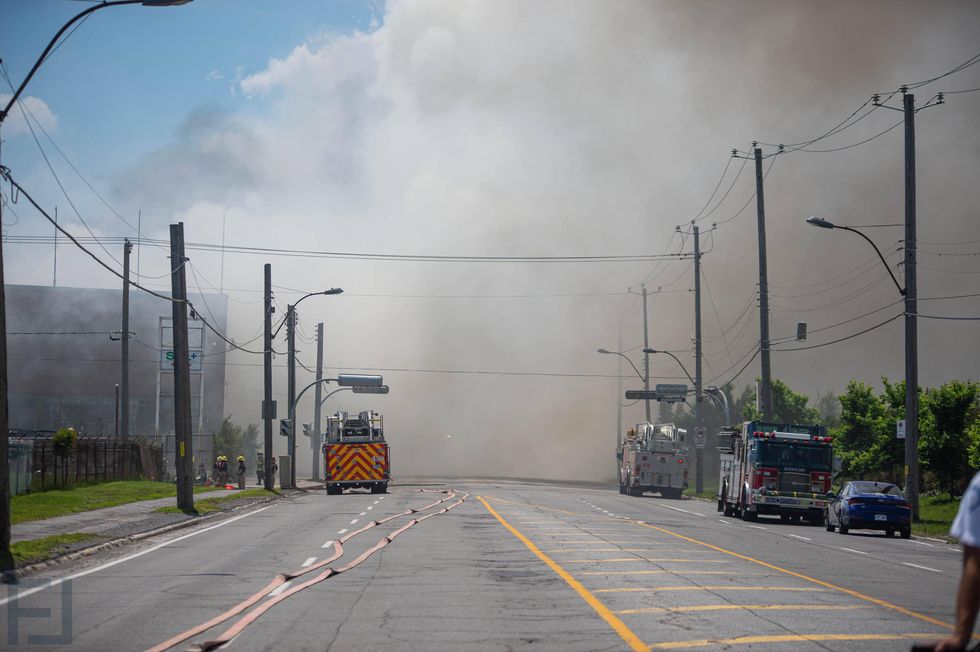 Smoke surrounds the area of a five-alarm fire in Montr\u00e9al-Est as firefighters respond on June 26.
