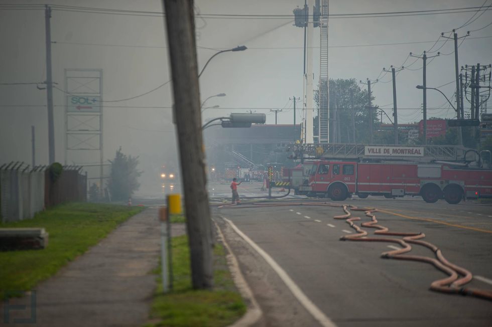 Smoke surrounds the area of a five-alarm fire in Montr\u00e9al-Est as firefighters respond on June 26.